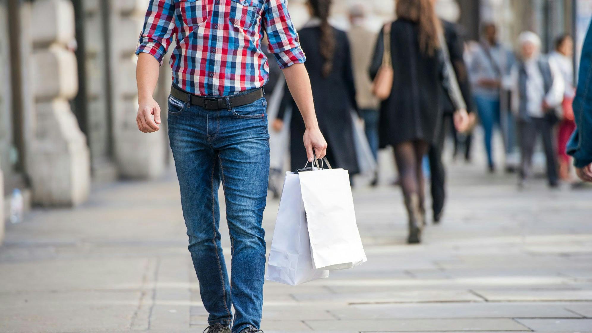 pmedia-man walking holding shopping bag loyal customer