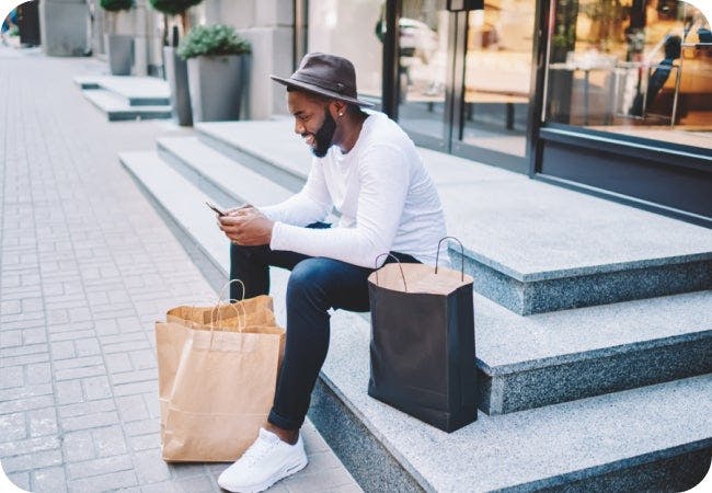 Image of person sitting on steps looking at their phone