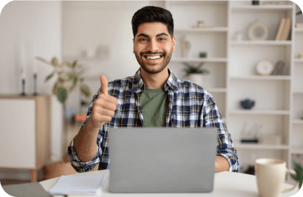 a person in a mostly white room giving a thumbs up from behind their laptop