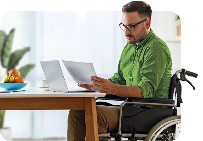 A person in a wheelchair working at a desk on a computer